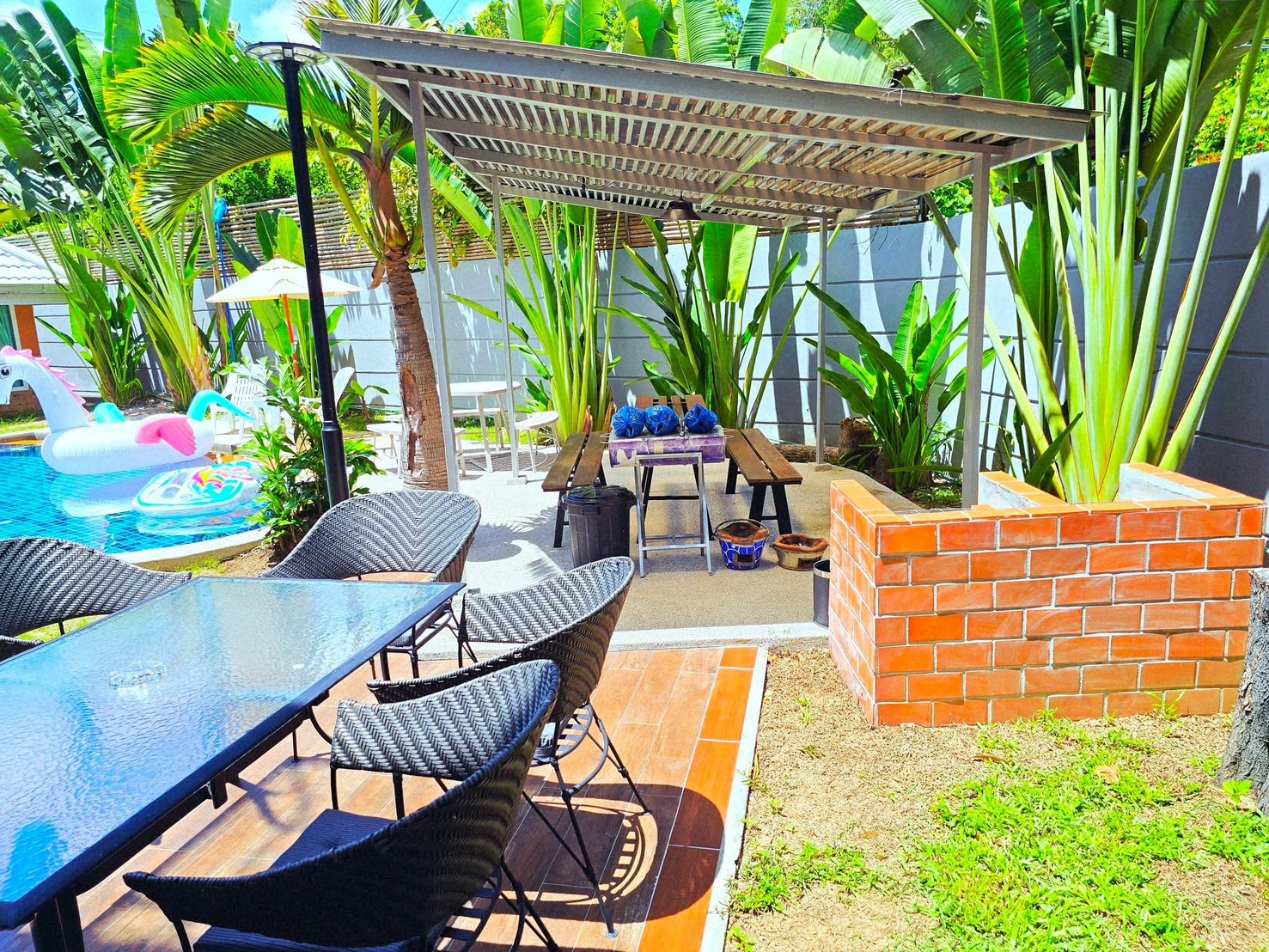 Outdoor pergola seating area surrounded by tropical plants
