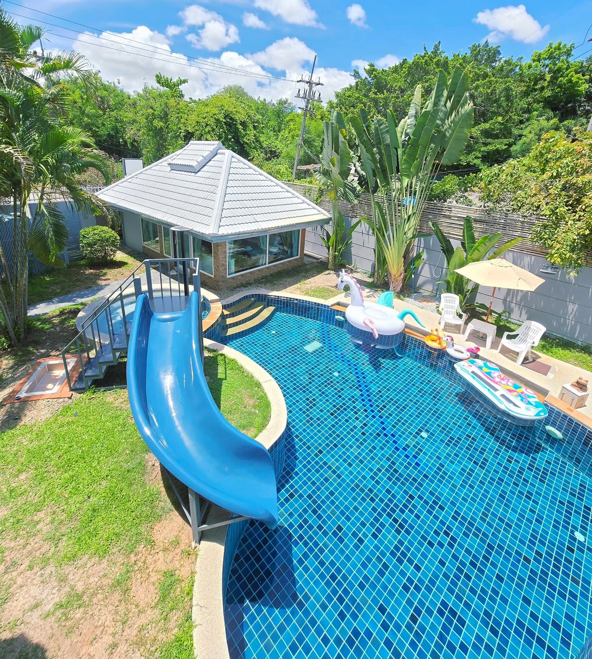 Aerial view of the private pool with water slide and unicorn float